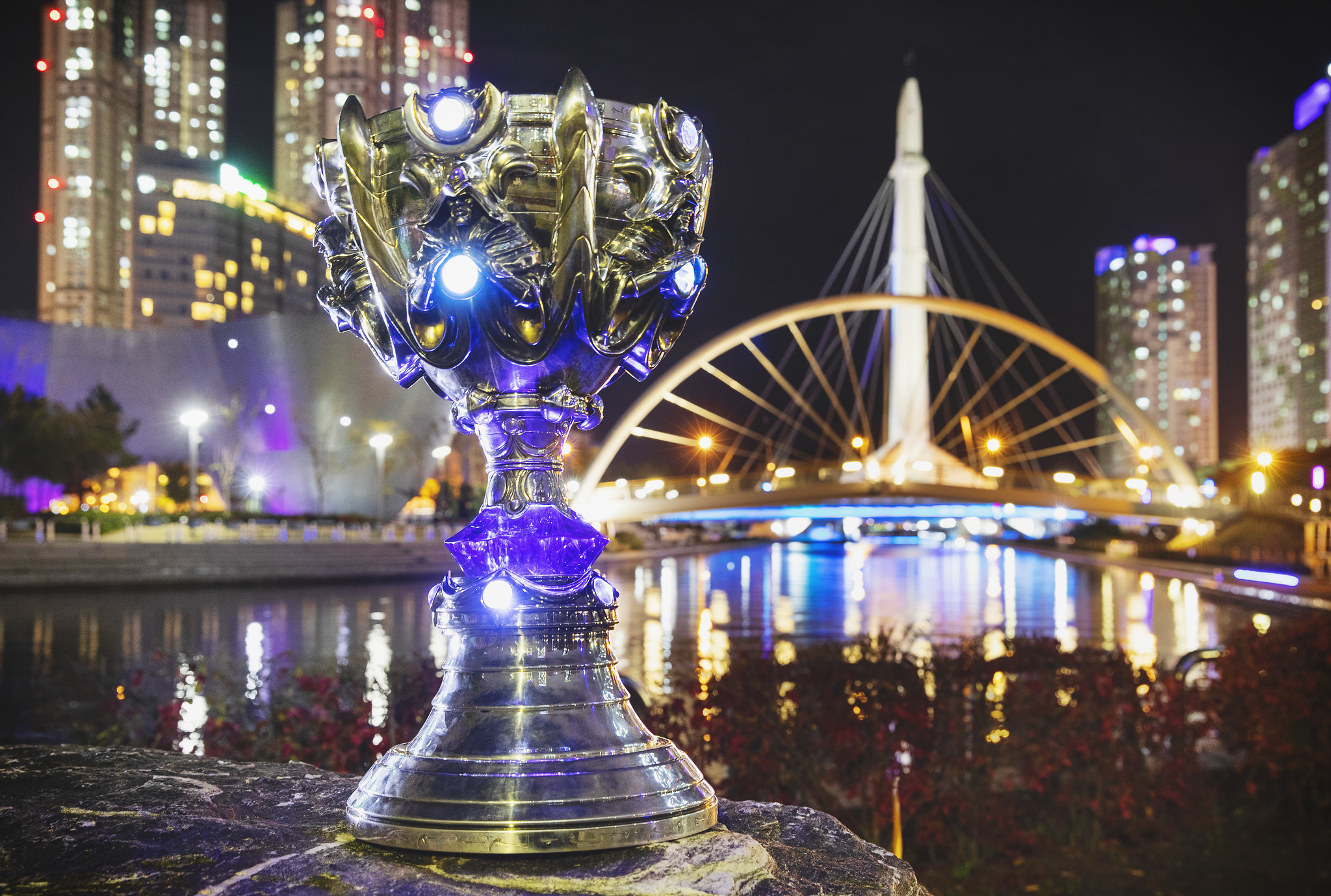 A League of Legends trophy sitting outside in a city at night