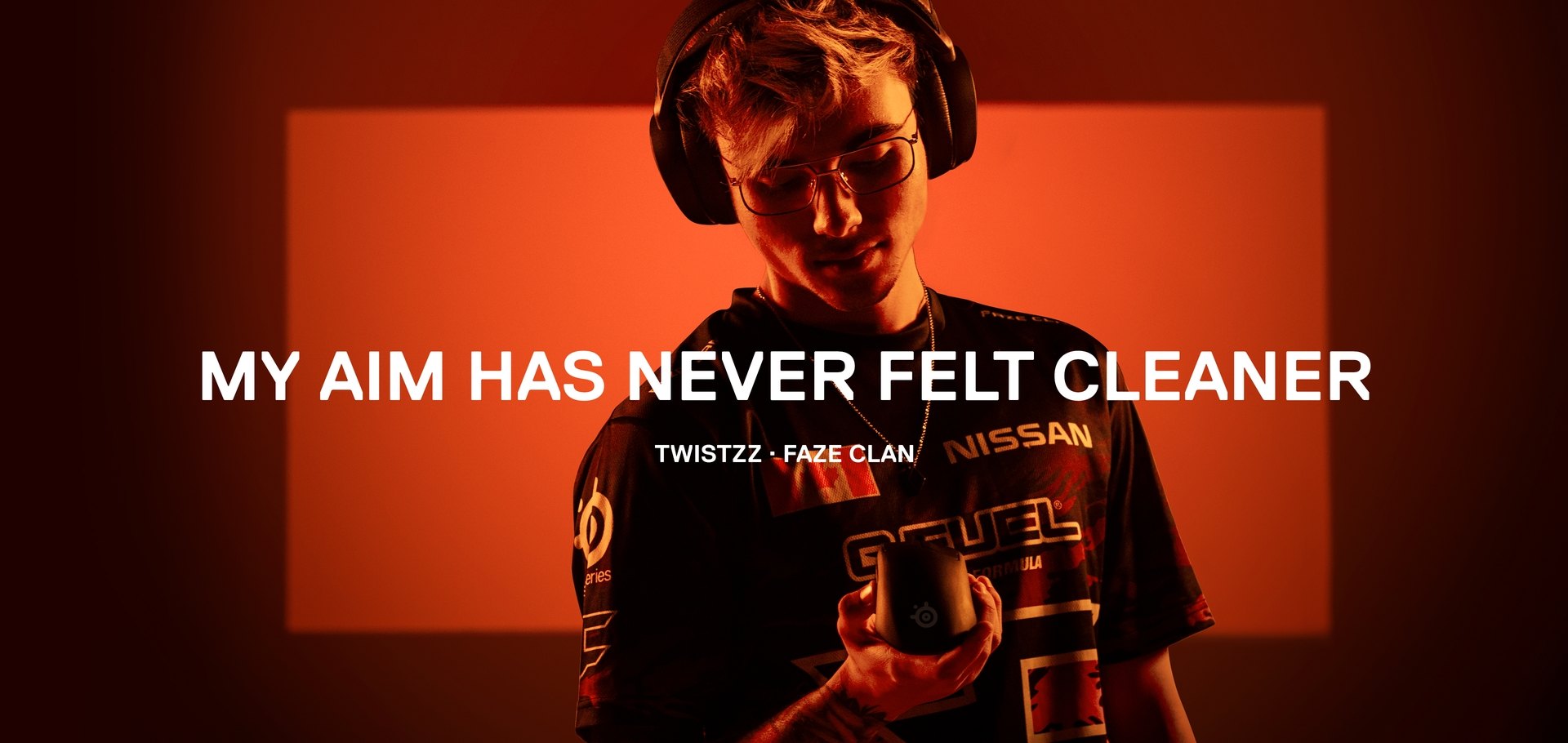 FaZe player Twistzz stands against an orange background holding the Prime mouse. Text on the image reads: "My aim has never felt cleaner."